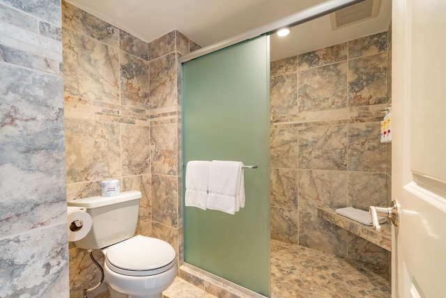 bathroom featuring toilet, tile walls, tile flooring, and walk in shower