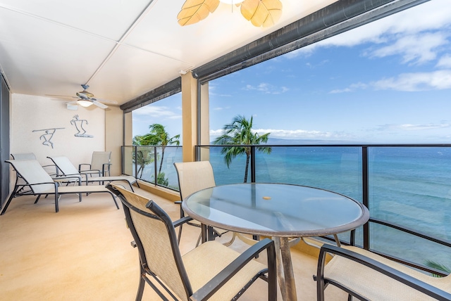 balcony featuring ceiling fan and a water view