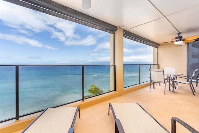 balcony with ceiling fan and a water view