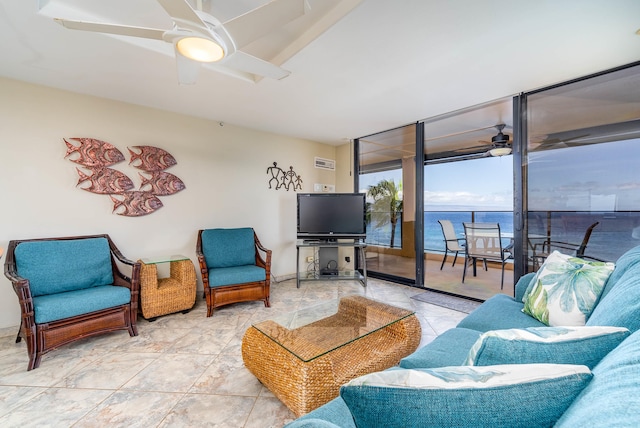 tiled living room featuring a water view, a wall of windows, and ceiling fan