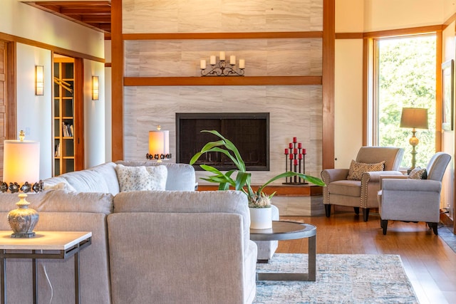 living room featuring hardwood / wood-style floors, a tiled fireplace, and plenty of natural light