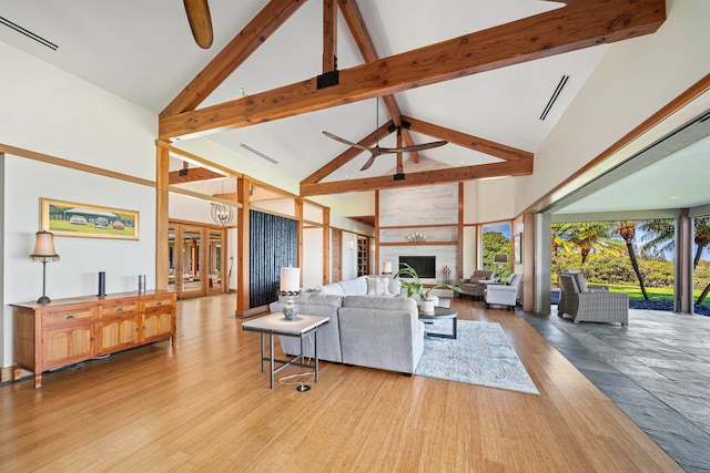 living room with light hardwood / wood-style floors, high vaulted ceiling, a fireplace, and ceiling fan