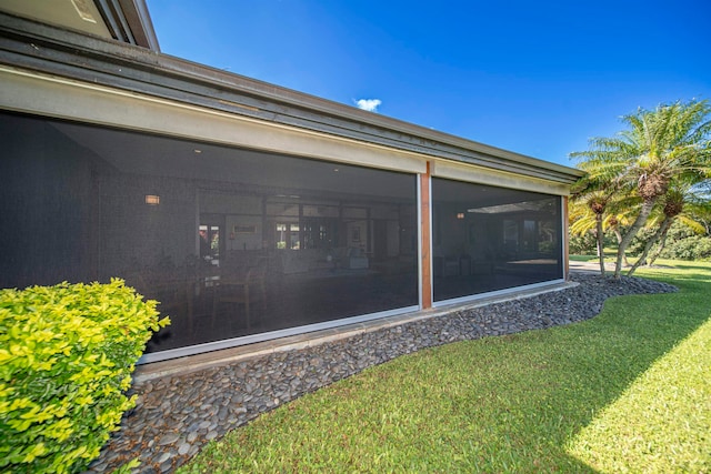 view of side of home with a yard and a sunroom