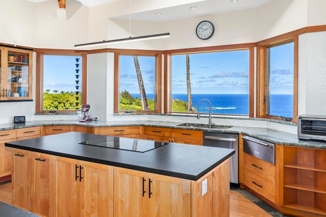 kitchen featuring light hardwood / wood-style flooring, black electric cooktop, dishwasher, sink, and a water view