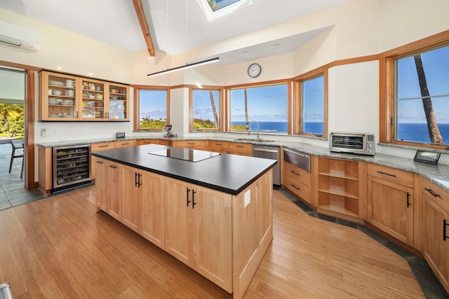 kitchen with black electric stovetop, wine cooler, a water view, and light wood-type flooring