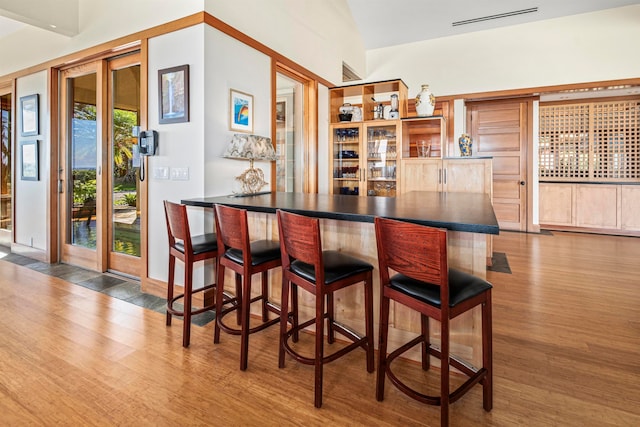 bar featuring hardwood / wood-style flooring and lofted ceiling