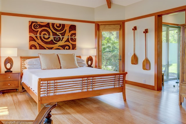 bedroom with lofted ceiling with beams, light wood-type flooring, and access to exterior