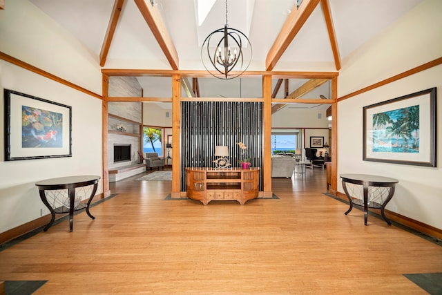 living room with a chandelier, high vaulted ceiling, light wood-type flooring, beamed ceiling, and a fireplace