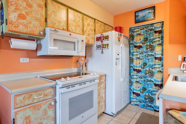 kitchen featuring light tile patterned flooring, sink, and white appliances