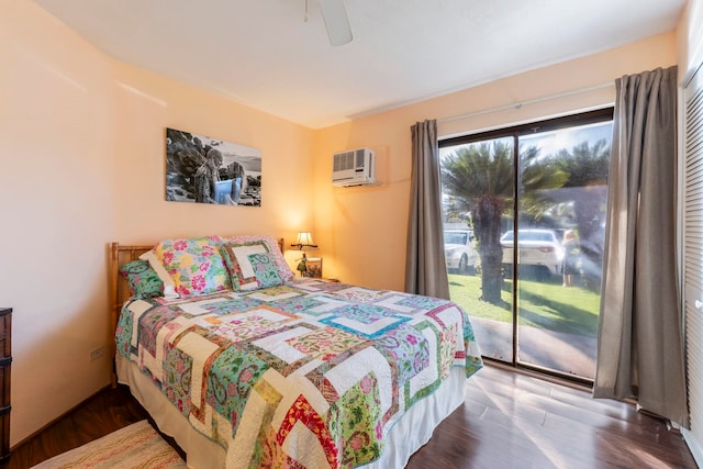 bedroom with dark wood-type flooring, ceiling fan, an AC wall unit, and access to outside