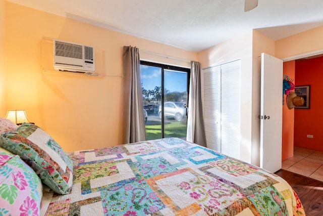 bedroom with a wall mounted air conditioner, access to outside, a closet, ceiling fan, and tile patterned flooring