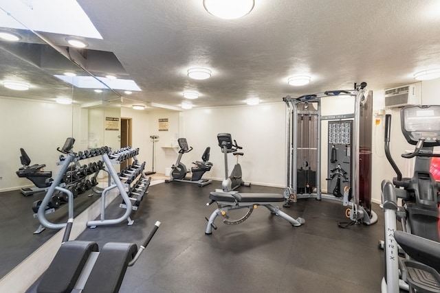 gym with a wall unit AC and a textured ceiling