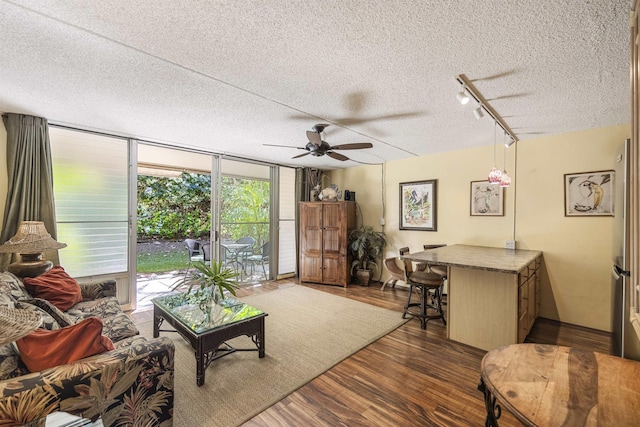 living room featuring floor to ceiling windows, ceiling fan, dark hardwood / wood-style flooring, track lighting, and a textured ceiling