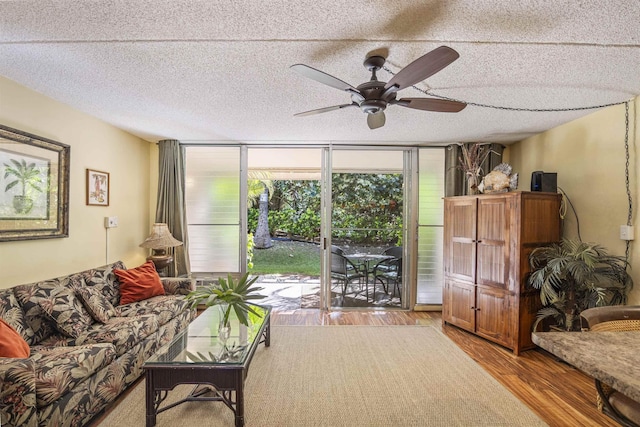 living room featuring a textured ceiling, expansive windows, light hardwood / wood-style flooring, and ceiling fan