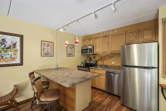 kitchen featuring dark wood-type flooring, stainless steel appliances, a kitchen breakfast bar, kitchen peninsula, and a textured ceiling