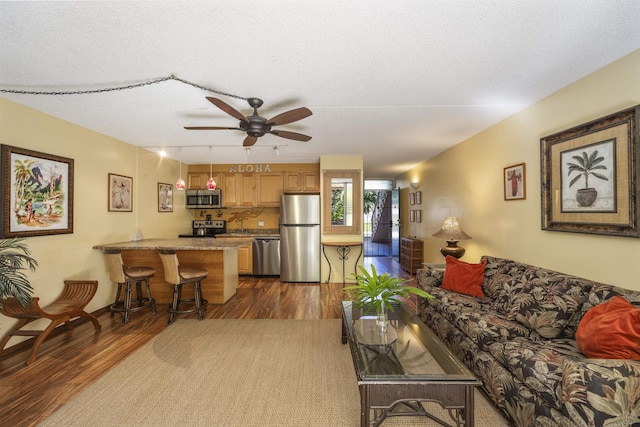 living room featuring a textured ceiling, ceiling fan, and dark wood-type flooring