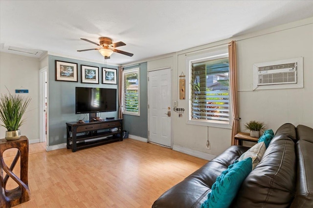 living room featuring a wall mounted air conditioner, ceiling fan, a wealth of natural light, and light hardwood / wood-style flooring