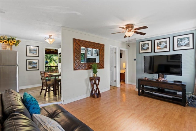 living room featuring ceiling fan, light hardwood / wood-style floors, and ornamental molding