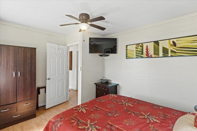 bedroom featuring light hardwood / wood-style flooring, ceiling fan, and ornamental molding