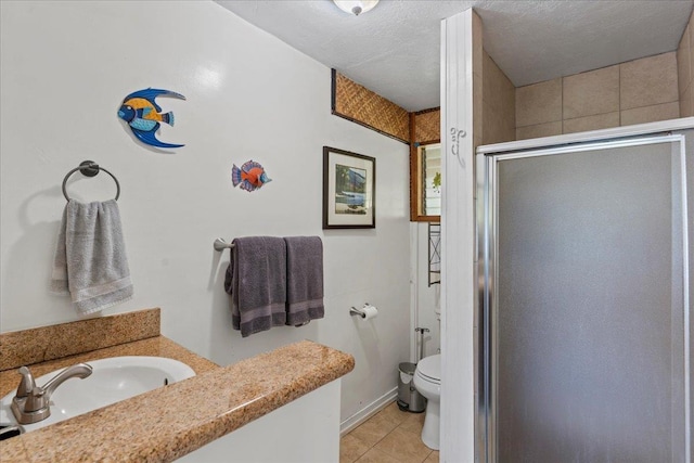 bathroom with tile patterned floors, a textured ceiling, toilet, vanity, and a shower with shower door