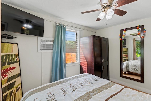 bedroom with a wall unit AC and ceiling fan