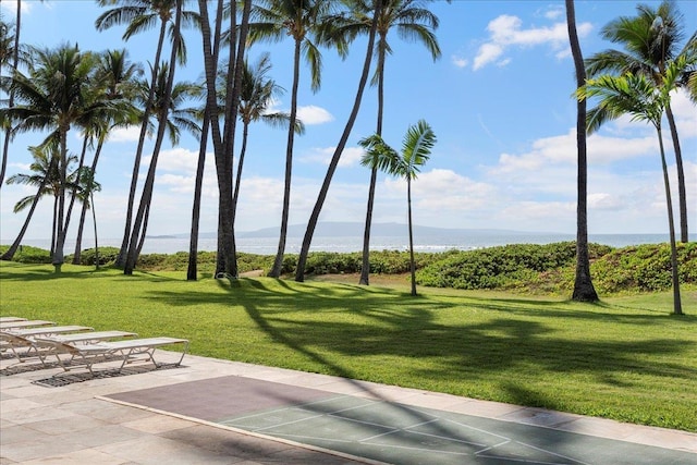 view of home's community with a water view and a lawn