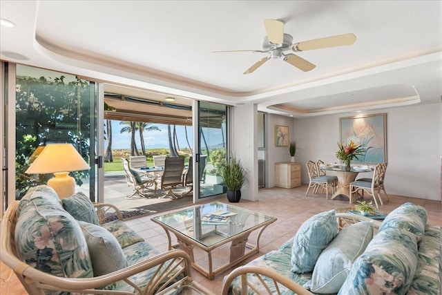 tiled living room featuring a tray ceiling and ceiling fan