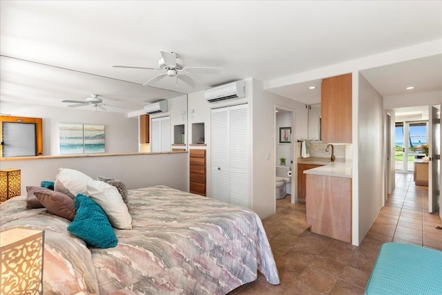 tiled bedroom with a wall mounted air conditioner, a closet, ensuite bath, and ceiling fan