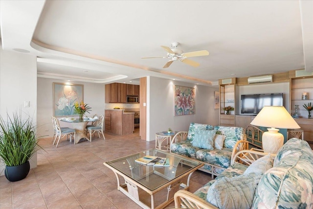 living room featuring an AC wall unit, ceiling fan, and a tray ceiling