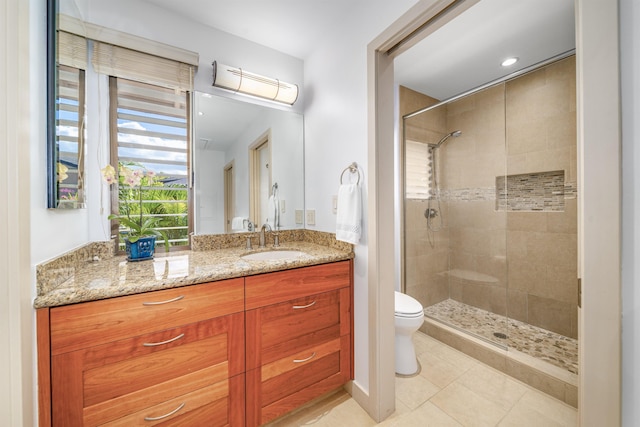 bathroom with tile patterned flooring, vanity, toilet, and tiled shower