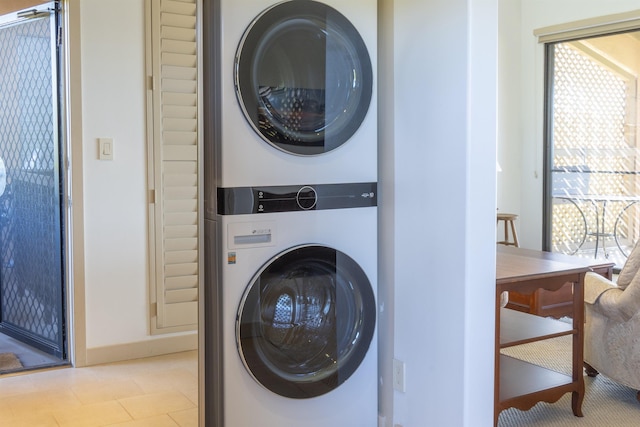 clothes washing area with stacked washing maching and dryer