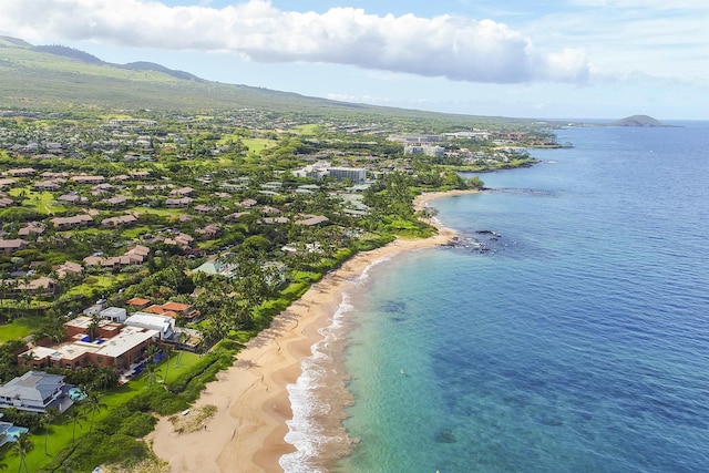 drone / aerial view featuring a water and mountain view and a beach view