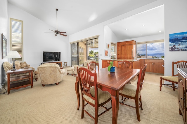 carpeted dining space featuring ceiling fan, sink, and vaulted ceiling