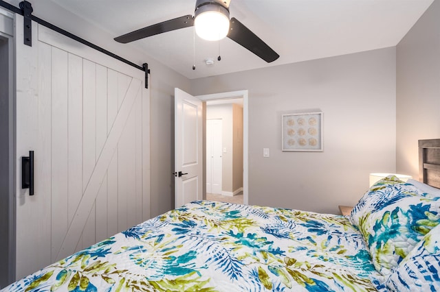 bedroom with a barn door and ceiling fan