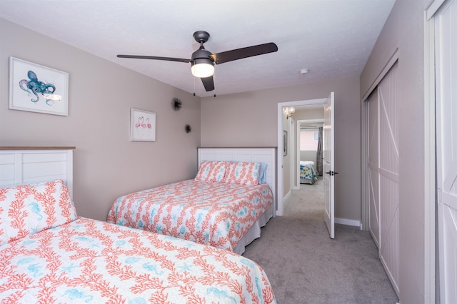 carpeted bedroom featuring ceiling fan and a closet