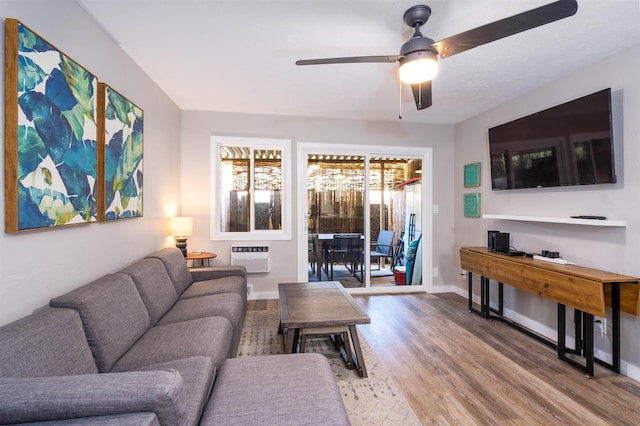 living room featuring ceiling fan, a wall mounted AC, and hardwood / wood-style floors