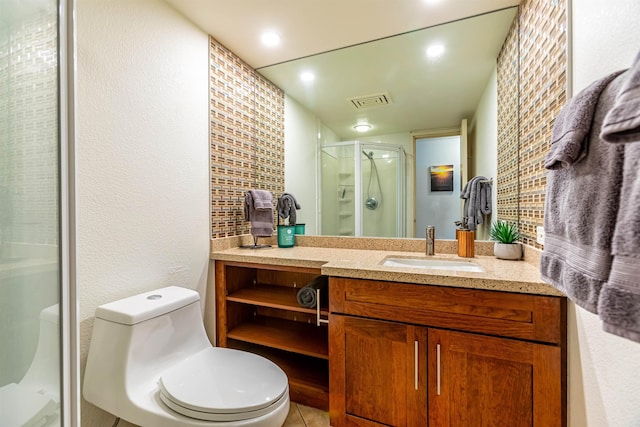 bathroom with toilet, vanity, visible vents, a stall shower, and a textured wall