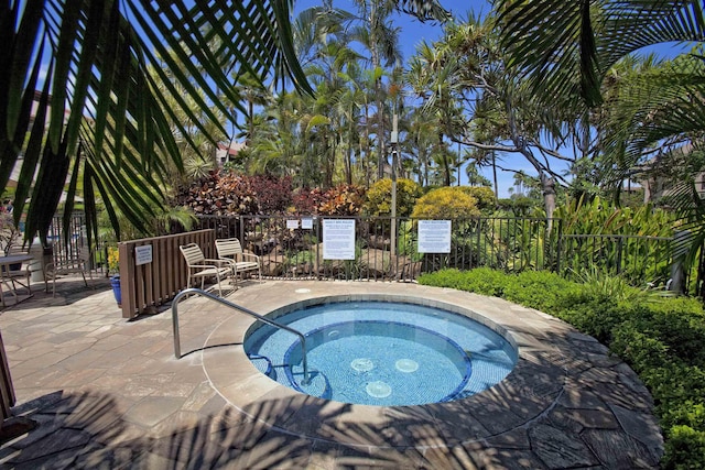 view of swimming pool featuring a hot tub, fence, and a patio area