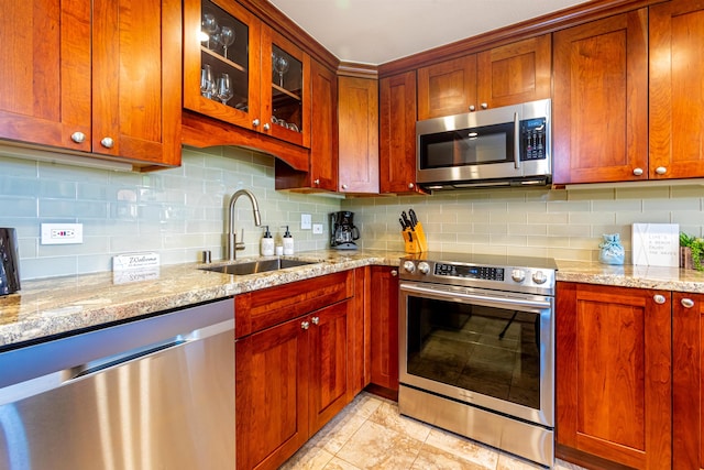 kitchen featuring appliances with stainless steel finishes, tasteful backsplash, and a sink