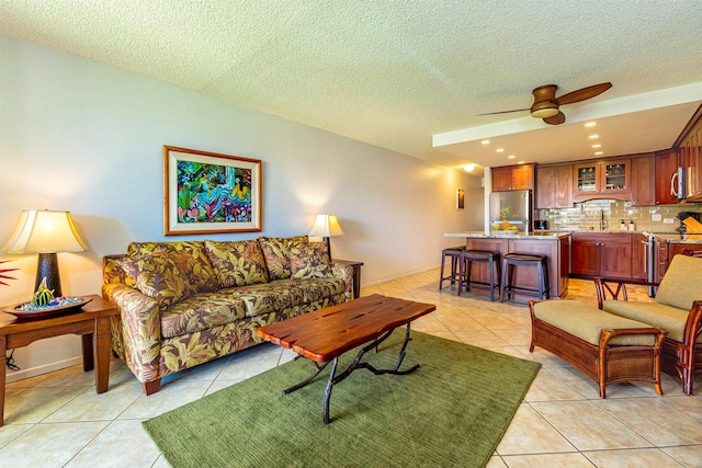 living room featuring a ceiling fan, recessed lighting, light tile patterned flooring, and a textured ceiling