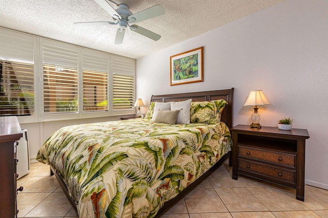 bedroom with light tile patterned floors, ceiling fan, and a textured ceiling