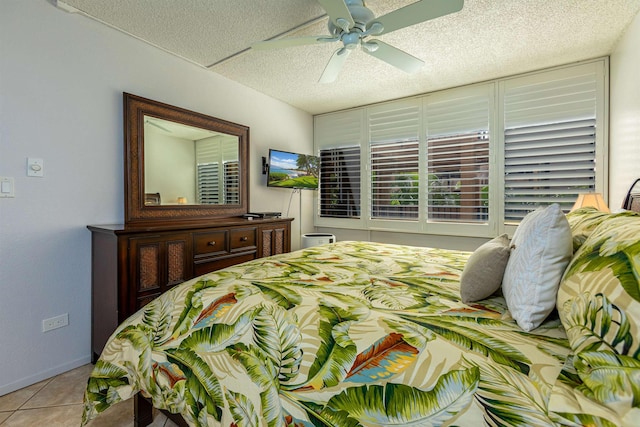 tiled bedroom featuring a textured ceiling, baseboards, and a ceiling fan