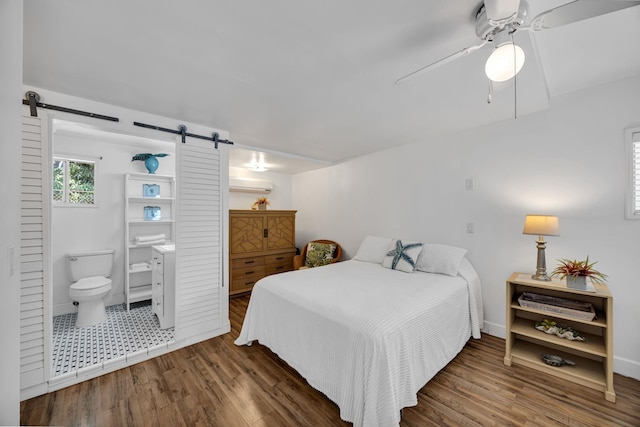 317 Kenolio Rd, Kihei, HI 96753 - bedroom with a wall mounted AC, baseboards, a barn door, ceiling fan, and wood finished floors