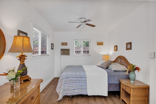 317 Kenolio Rd, Kihei, HI 96753 - bedroom with baseboards, a wall unit AC, wood finished floors, and ceiling fan