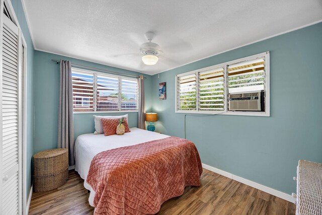 317 Kenolio Rd, Kihei, HI 96753 - bedroom with a closet, cooling unit, wood finished floors, baseboards, and ceiling fan