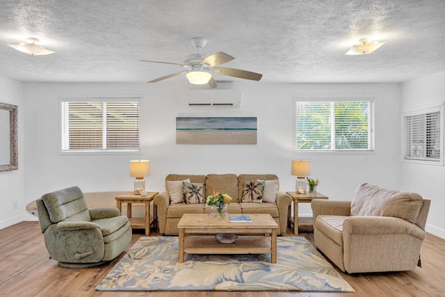 317 Kenolio Rd, Kihei, HI 96753 - living room featuring a textured ceiling, a wall mounted AC, wood finished floors, and a ceiling fan