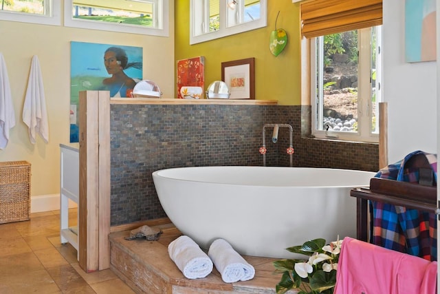 bathroom with tile walls, tile flooring, and a wealth of natural light