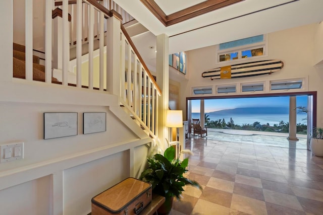 staircase featuring light tile floors and a high ceiling