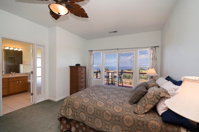 bedroom featuring ceiling fan, sink, ensuite bath, access to exterior, and light colored carpet