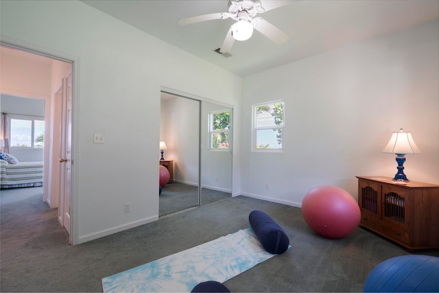 workout room with plenty of natural light, dark carpet, and ceiling fan